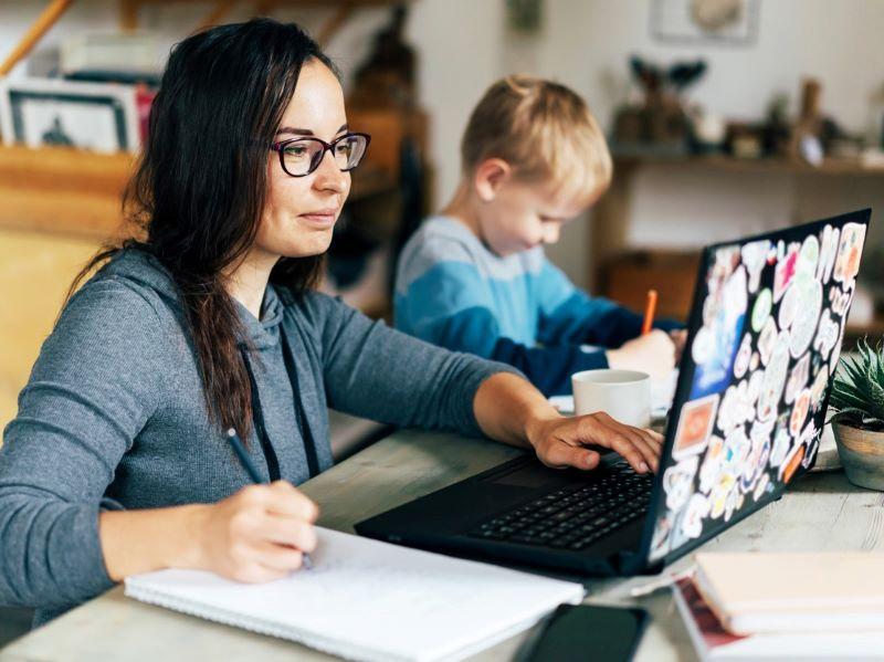 A mature student studying next to her son