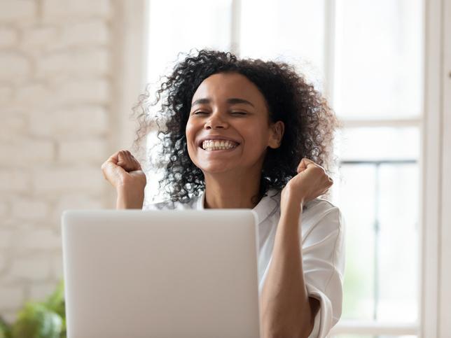 Young woman celebrating with laptop