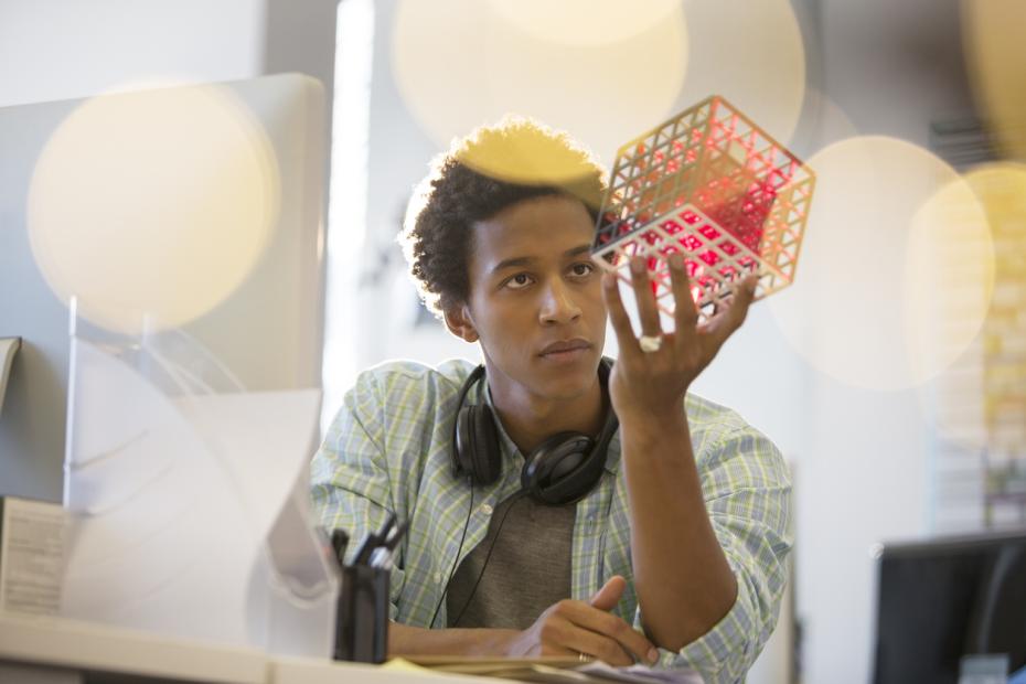 A young man gazes are a gridded cube