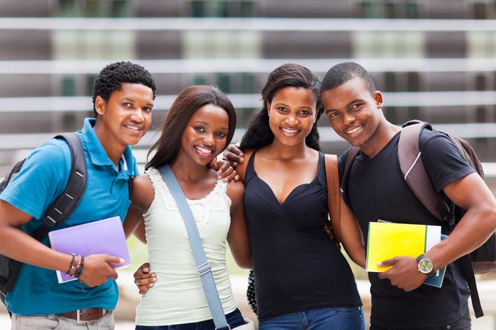 Four Black students pose on campus