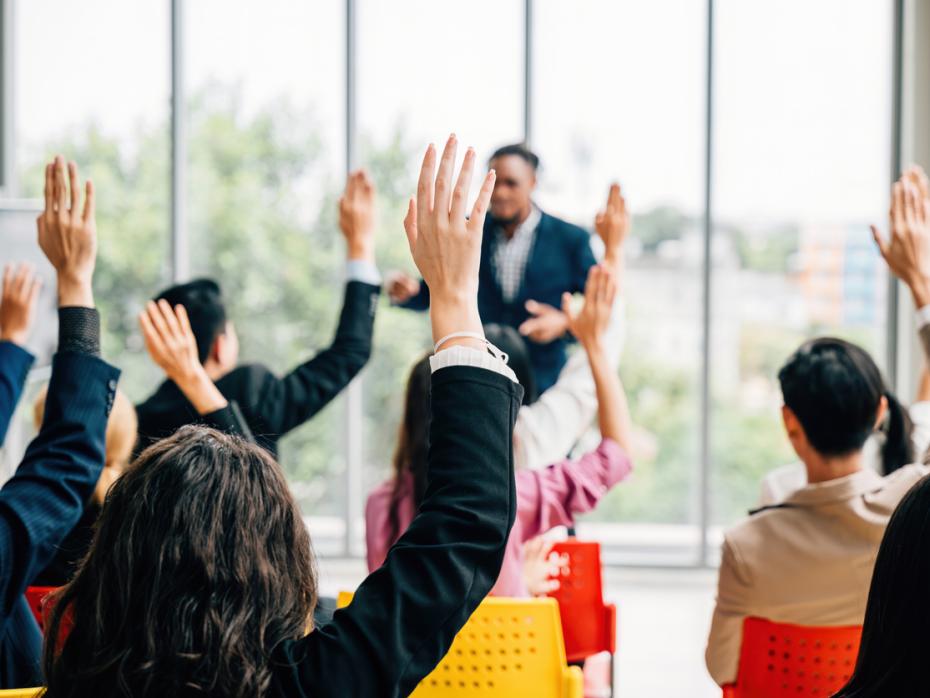 Students with their hands up in class