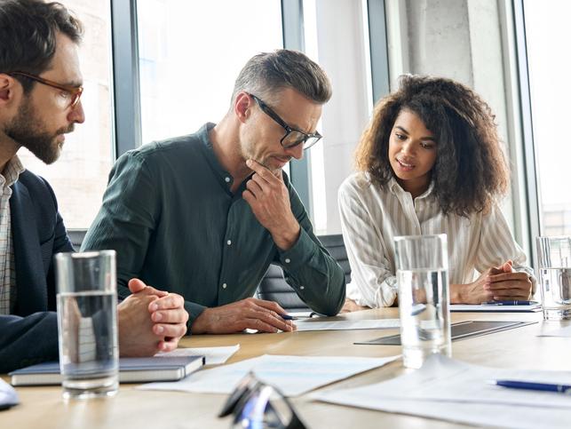 Three business people consider a document