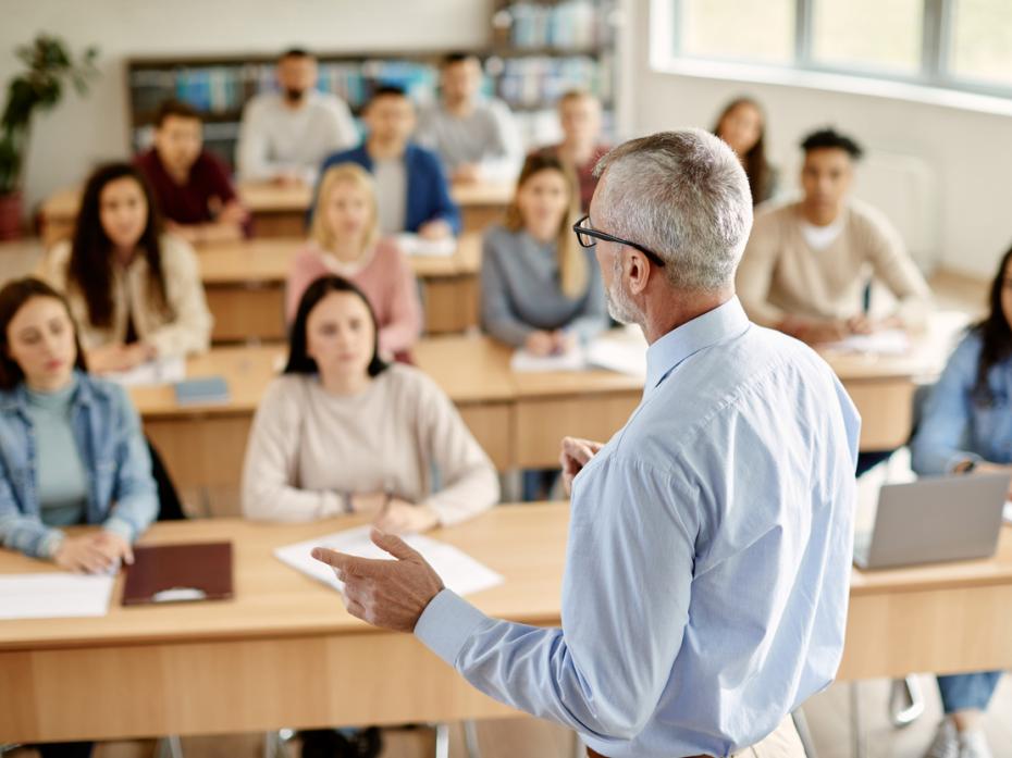 A teacher giving a lecture at the front of class