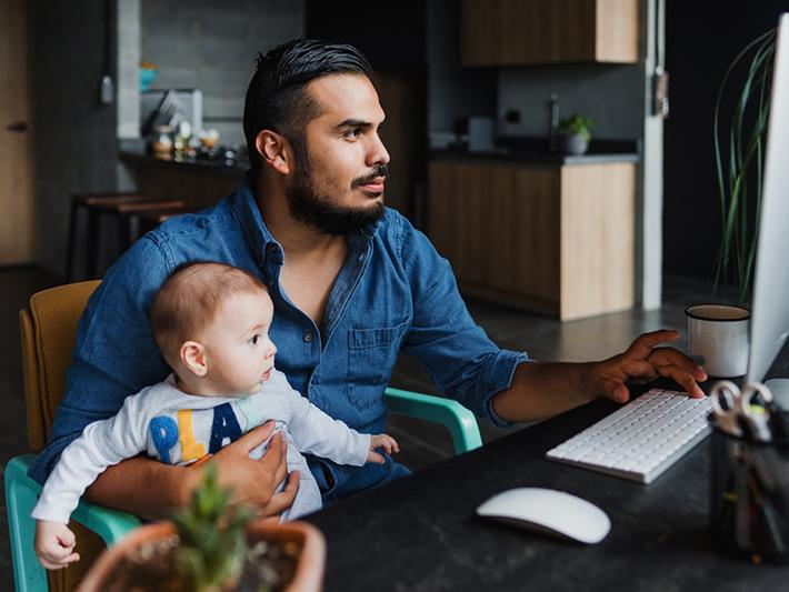 Latin American father working from home with toddler