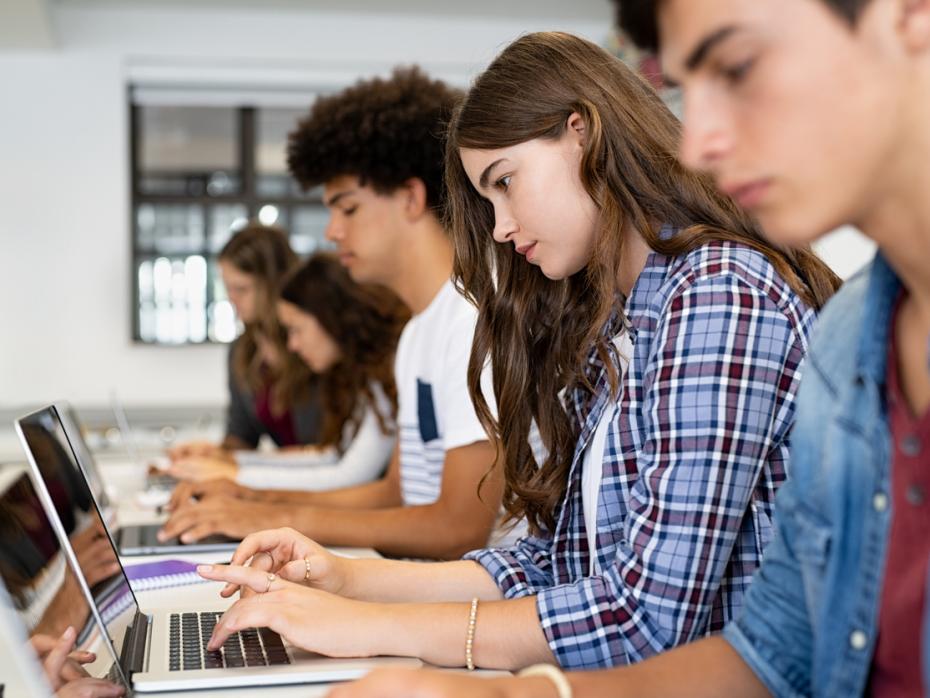 Students working at their laptops in class