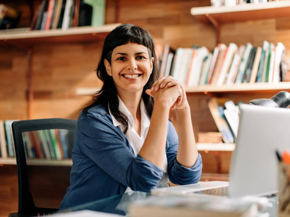 Female lecturer at her laptop smiling to camera