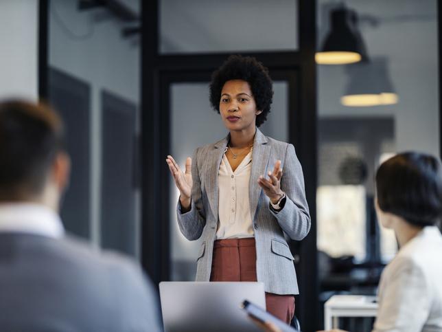 A woman gives a talk to a room of people