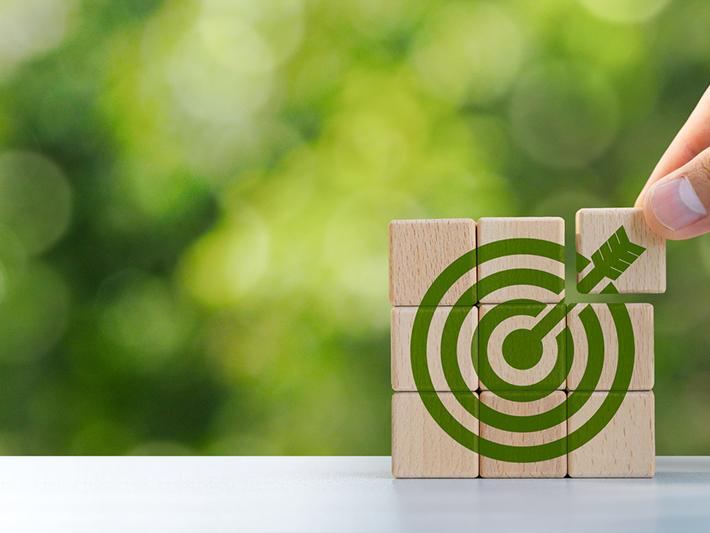 Green target on building blocks, sustainability