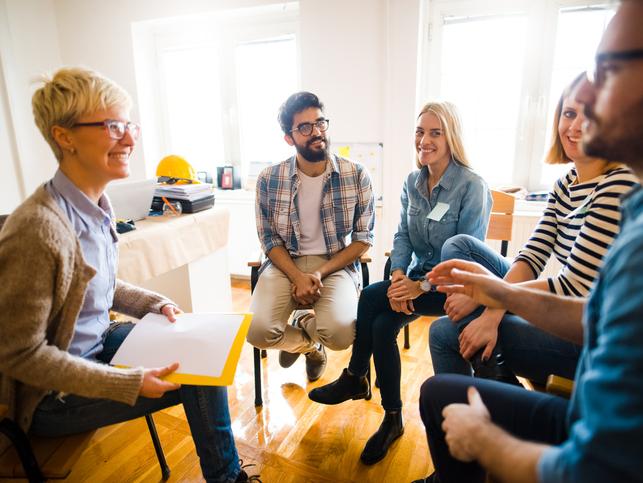 A group of people sit around in discussion