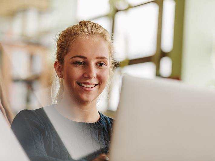 Young student smiling with laptop