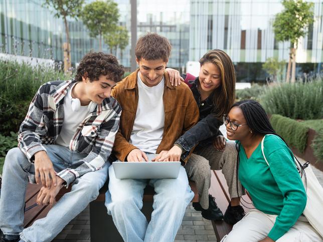 Students work round a laptop together