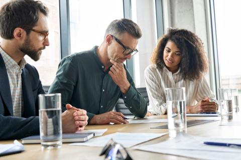 Three business people consider a document