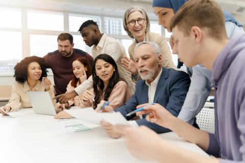 A group of people brainstorm around an office table