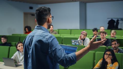 A lecturer speaks to a group of students