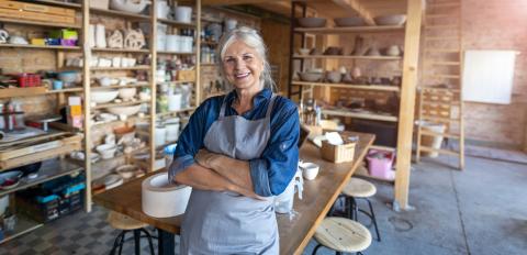 Female artist in her studio smiling to camera