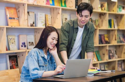 East asian students in a library working together