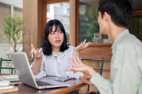 Student speaking to a teacher in front of laptop