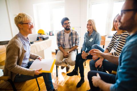 A group of people sit around in discussion