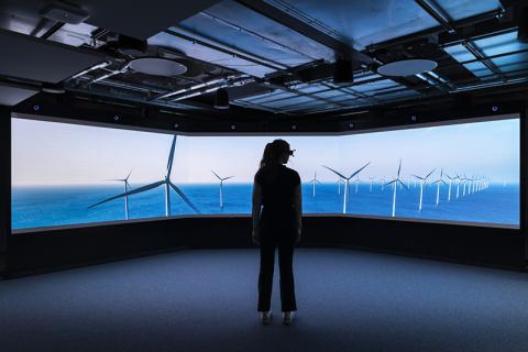 Woman in VR headset against image of wind farm