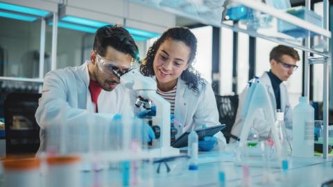 Two science students use a microscope together