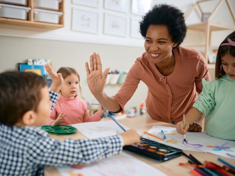 Image of a young woman working with school children