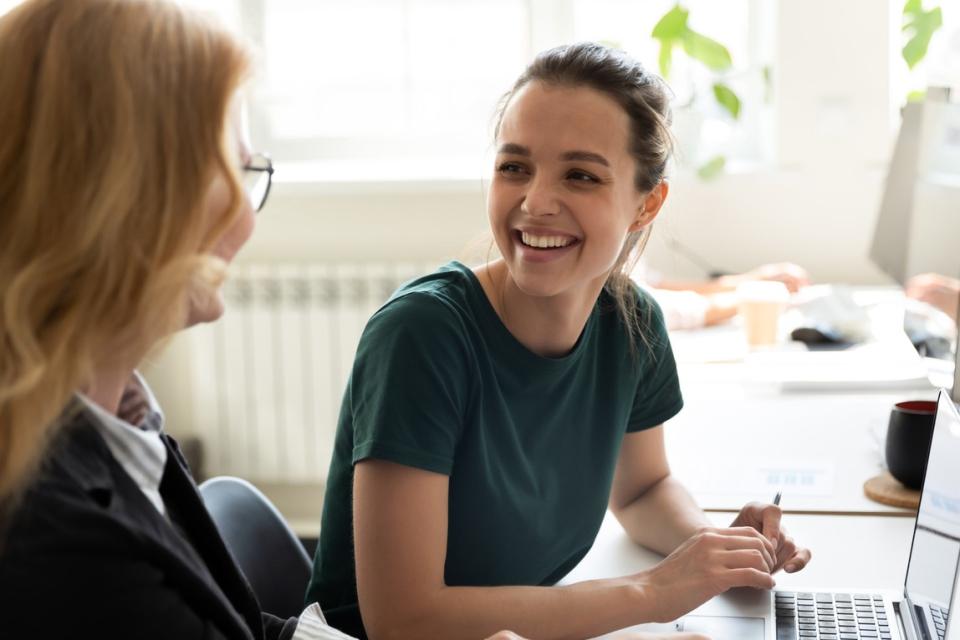 Two colleagues speaking to one another by a computer