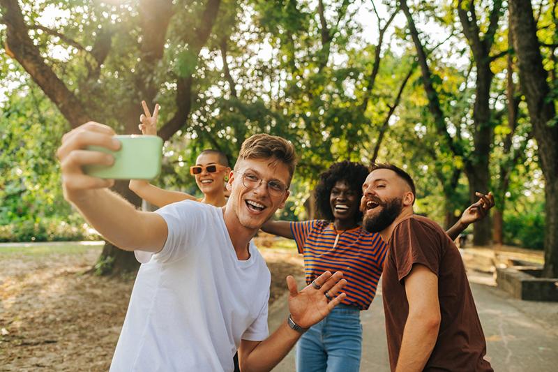 Multiracial group of students taking a selfie in the park