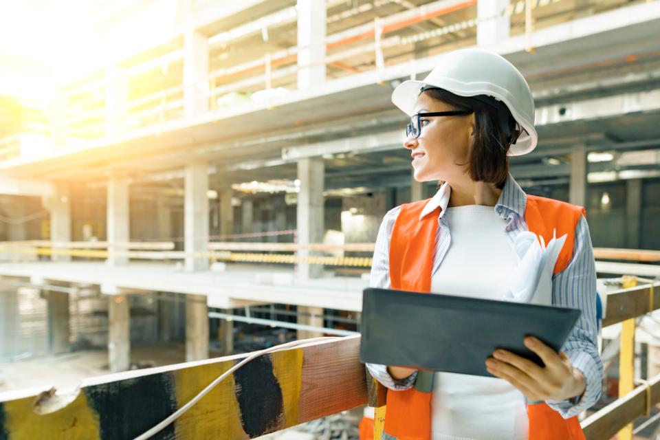 Female construction worker surveying a building