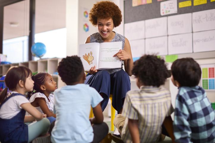 A teacher reads a story to her primary school class