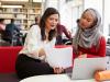 A tutor talking to a student in the library