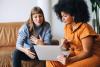 Two female colleagues discussing some work over a laptop