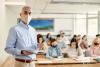 A masked teacher leads a class