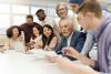 A group of people brainstorm around an office table