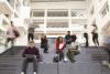 Students sitting on the stairs of a university campus building