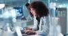 Female researcher working on her laptop in a lab