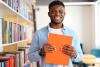 A student in the library holds a book