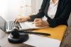 young woman working at laptop with gavel in foreground