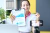 A woman holds up a bar chart to an iPhone camera