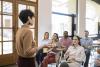 Female lecturer speaking to students at the front of class